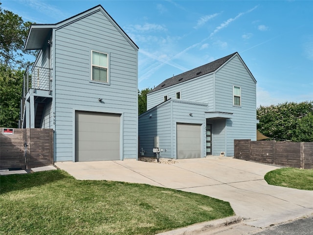 6920 Bethune Ave, Austin, TX 78752 - view of side of home featuring an attached garage, concrete driveway, and a balcony