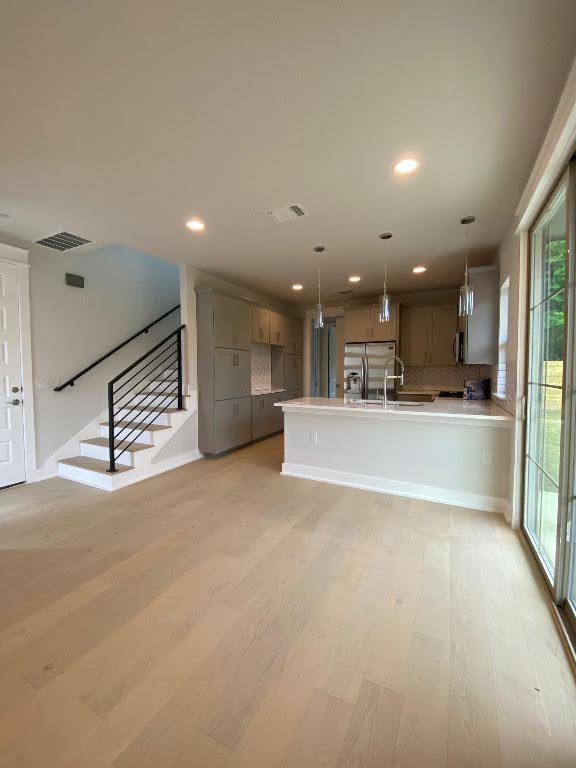 6920 Bethune Ave, Austin, TX 78752 - unfurnished living room featuring light wood-type flooring, stairs, and recessed lighting
