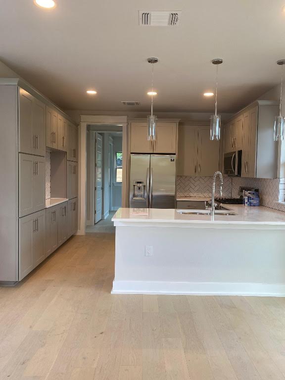 6920 Bethune Ave, Austin, TX 78752 - kitchen featuring appliances with stainless steel finishes, gray cabinetry, backsplash, a peninsula, and recessed lighting