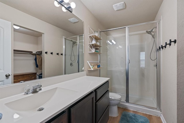 233 Voss, Kyle, TX 78640 - full bath featuring a stall shower, vanity, a walk in closet, and wood finished floors