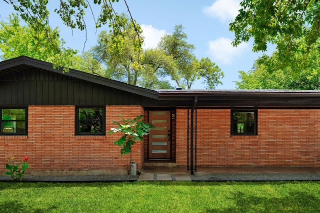 1405 Ridgehaven Dr, Austin, TX 78723 - view of exterior entry with a yard and brick siding