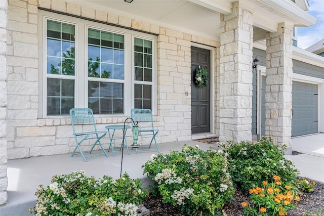 2049 Cartway Ct, Leander, TX 78641 - doorway to property featuring a porch, stone siding, an attached garage, and concrete driveway