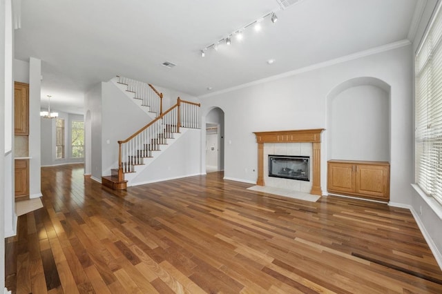 3213 Summer Canyon Dr, Austin, TX 78732 - unfurnished living room featuring a fireplace, wood finished floors, stairs, and ornamental molding