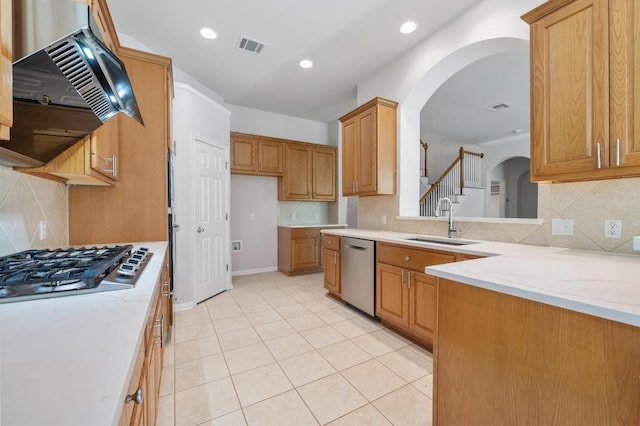 3213 Summer Canyon Dr, Austin, TX 78732 - kitchen featuring appliances with stainless steel finishes, exhaust hood, arched walkways, tasteful backsplash, and recessed lighting
