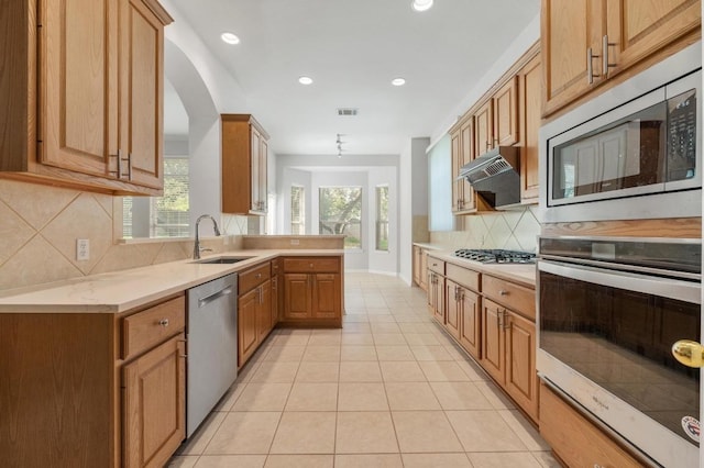 3213 Summer Canyon Dr, Austin, TX 78732 - kitchen with stainless steel appliances, decorative backsplash, light tile patterned floors, recessed lighting, and a peninsula