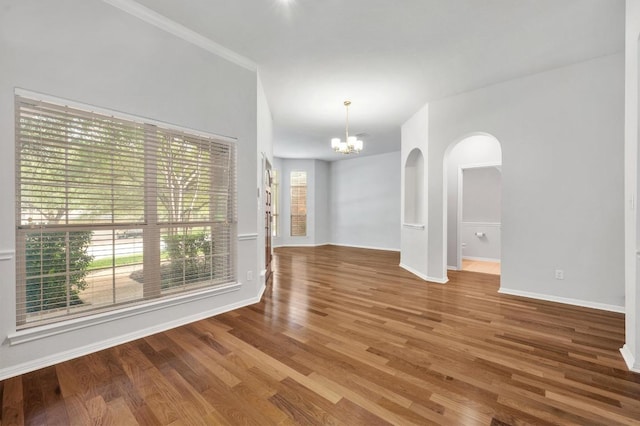 3213 Summer Canyon Dr, Austin, TX 78732 - spare room featuring a chandelier, wood finished floors, and arched walkways