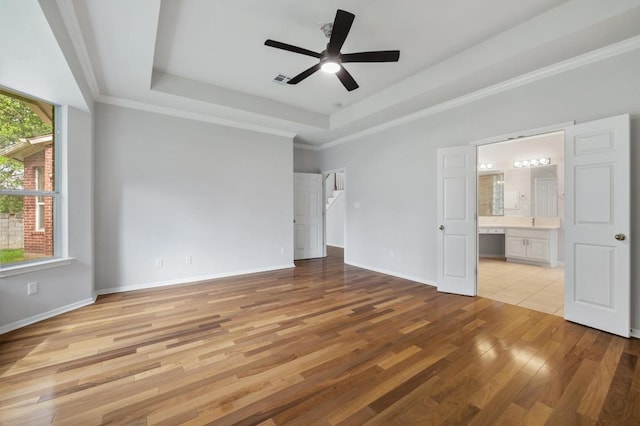 3213 Summer Canyon Dr, Austin, TX 78732 - unfurnished bedroom with a tray ceiling, light wood-style flooring, connected bathroom, ceiling fan, and crown molding