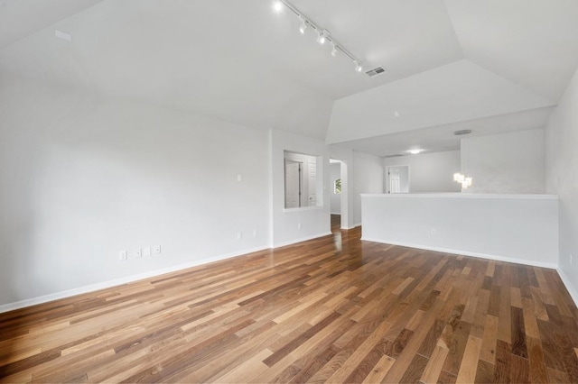 3213 Summer Canyon Dr, Austin, TX 78732 - unfurnished living room with rail lighting, wood finished floors, and high vaulted ceiling