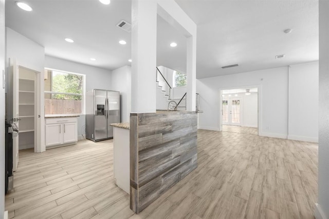 8104 Broken Branch Dr, Round Rock, TX 78681 - unfurnished living room with light wood-style flooring, stairs, and recessed lighting