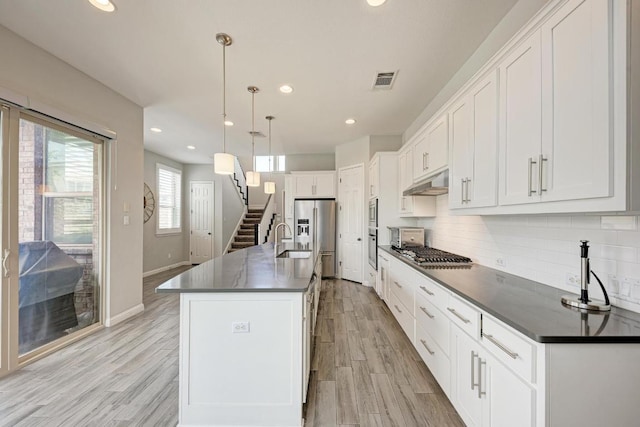 600 E Baylee Love Ln, Austin, TX 78717 - kitchen featuring under cabinet range hood, dark countertops, appliances with stainless steel finishes, white cabinetry, and recessed lighting