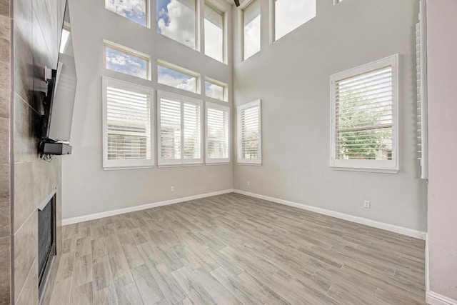 600 E Baylee Love Ln, Austin, TX 78717 - unfurnished living room featuring light wood-style floors, healthy amount of natural light, and a fireplace