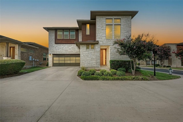 600 E Baylee Love Ln, Austin, TX 78717 - modern home featuring stone siding, an attached garage, and concrete driveway