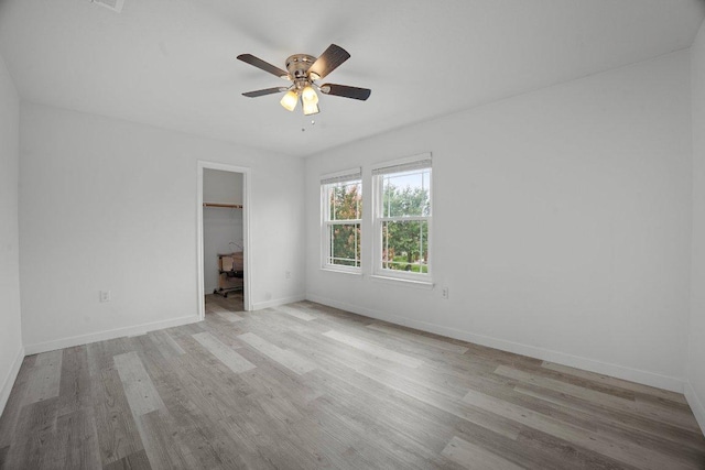 7625 Cayenne Ln, Austin, TX 78741 - unfurnished bedroom with wood finished floors, a spacious closet, and ceiling fan