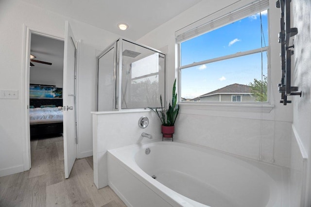 7625 Cayenne Ln, Austin, TX 78741 - bathroom featuring ensuite bathroom, a garden tub, a stall shower, and wood finished floors