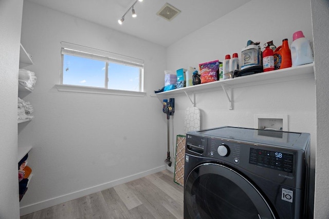 7625 Cayenne Ln, Austin, TX 78741 - washroom featuring washer / dryer, wood finished floors, and rail lighting