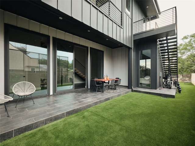 412 Kemp St, Austin, TX 78741 - back of property featuring board and batten siding, a balcony, a lawn, and a patio