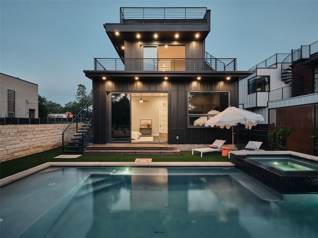 412 Kemp St, Austin, TX 78741 - back of house featuring stairway, a balcony, and a pool with connected hot tub
