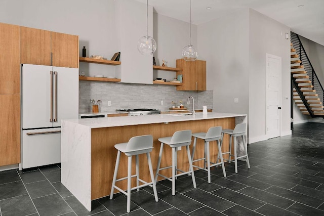 412 Kemp St, Austin, TX 78741 - kitchen with high end fridge, open shelves, a towering ceiling, decorative backsplash, and light countertops
