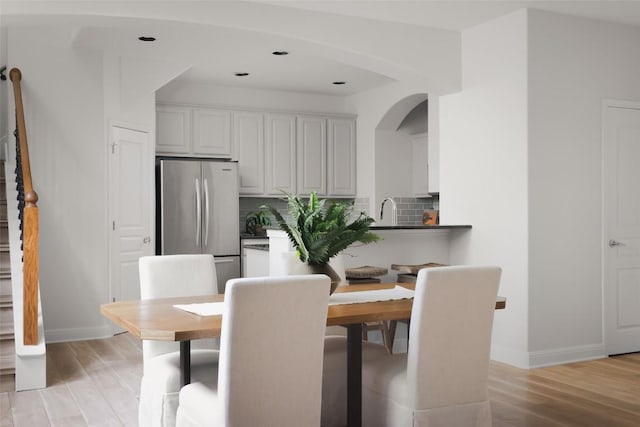 3406 Menchaca Rd Unit 14, Austin, TX 78704 - dining room featuring light wood finished floors, arched walkways, recessed lighting, and stairway