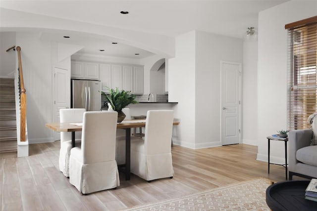 3406 Menchaca Rd Unit 14, Austin, TX 78704 - dining space with stairway, light wood finished floors, arched walkways, and recessed lighting