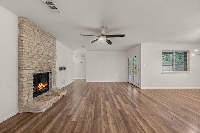 7604 Beinville Cv, Austin, TX 78749 - unfurnished living room featuring a ceiling fan, a stone fireplace, and wood finished floors