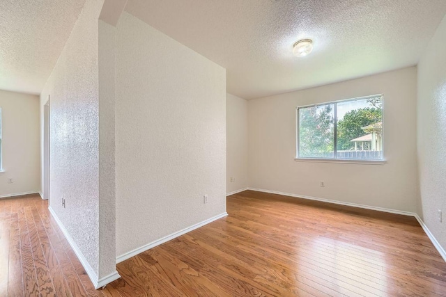 1506 Willow Bluff Dr, Pflugerville, TX 78660 - empty room featuring a textured ceiling, hardwood / wood-style floors, and a textured wall