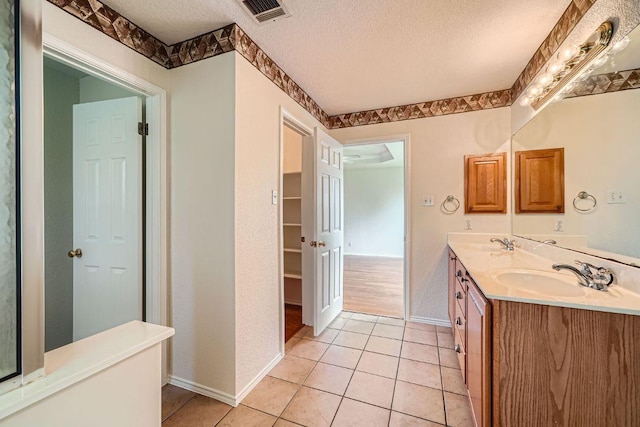 1506 Willow Bluff Dr, Pflugerville, TX 78660 - bathroom with a textured ceiling, double vanity, and tile patterned flooring