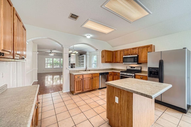 1506 Willow Bluff Dr, Pflugerville, TX 78660 - kitchen featuring ornate columns, arched walkways, appliances with stainless steel finishes, light countertops, and vaulted ceiling