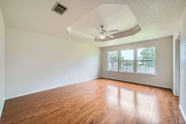 1506 Willow Bluff Dr, Pflugerville, TX 78660 - spare room with hardwood / wood-style floors, a textured ceiling, a ceiling fan, and a tray ceiling