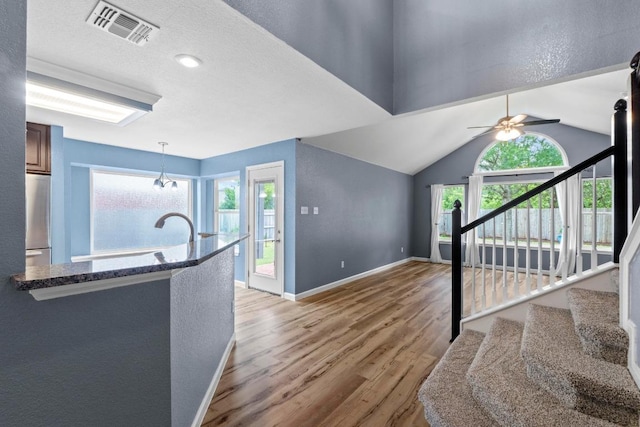 9105 Trickle Trace Trl, Round Rock, TX 78681 - kitchen featuring freestanding refrigerator, light wood-type flooring, healthy amount of natural light, ceiling fan, and vaulted ceiling