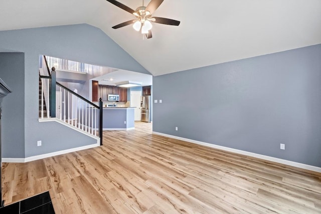9105 Trickle Trace Trl, Round Rock, TX 78681 - unfurnished living room featuring a ceiling fan, stairway, vaulted ceiling, light wood finished floors, and a fireplace