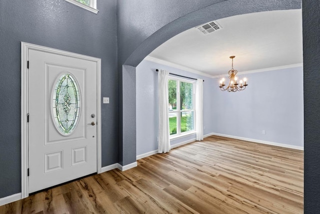 9105 Trickle Trace Trl, Round Rock, TX 78681 - entryway with arched walkways, crown molding, wood finished floors, and a chandelier