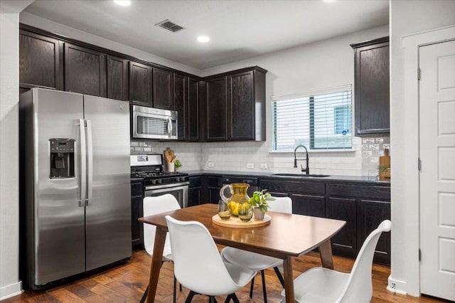 2101 Rivers Edge Way Unit 17, Austin, TX 78741 - kitchen featuring stainless steel appliances, dark countertops, recessed lighting, dark brown cabinets, and backsplash
