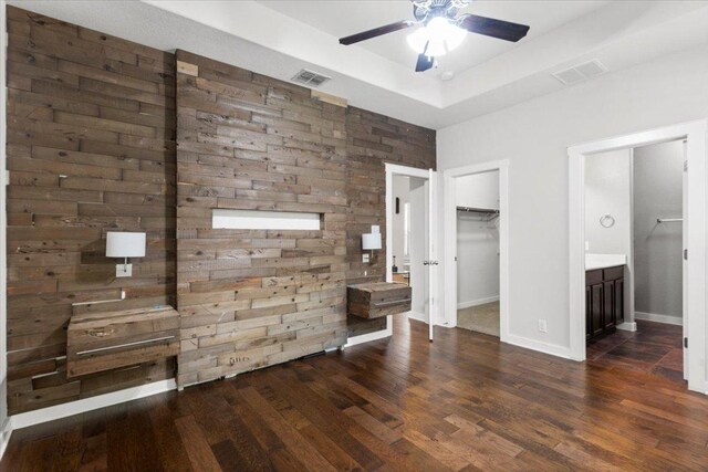 2101 Rivers Edge Way Unit 17, Austin, TX 78741 - unfurnished bedroom with wood finished floors, a tray ceiling, a walk in closet, ensuite bath, and a ceiling fan