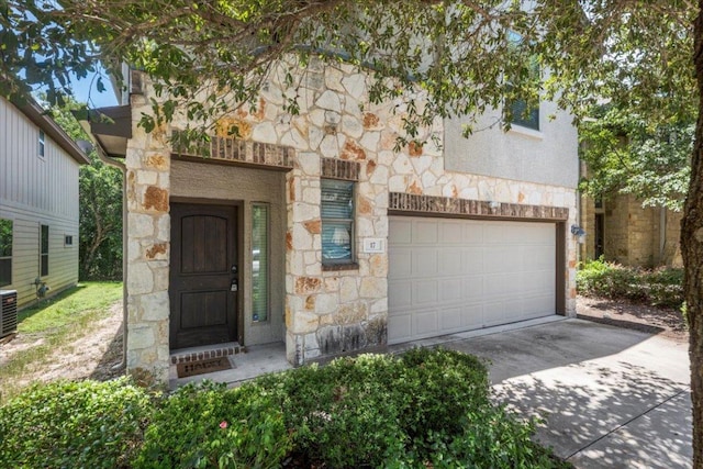 2101 Rivers Edge Way Unit 17, Austin, TX 78741 - property entrance featuring stone siding, driveway, and an attached garage