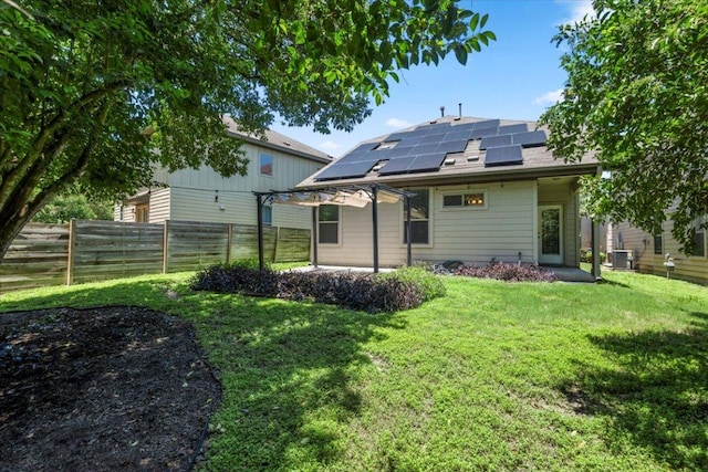 2101 Rivers Edge Way Unit 17, Austin, TX 78741 - back of house with a patio, roof mounted solar panels, a fenced backyard, and a shingled roof