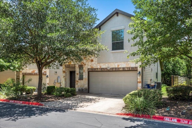 2101 Rivers Edge Way Unit 17, Austin, TX 78741 - view of front of house with stone siding, an attached garage, concrete driveway, and stucco siding