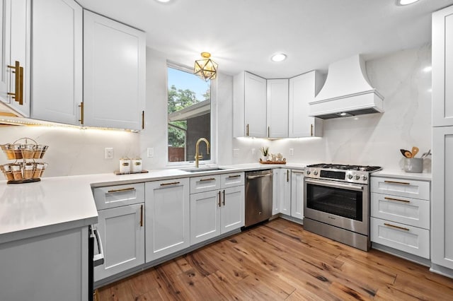 2306 Westoak Dr, Austin, TX 78704 - kitchen with stainless steel appliances, premium range hood, recessed lighting, wood finished floors, and light countertops