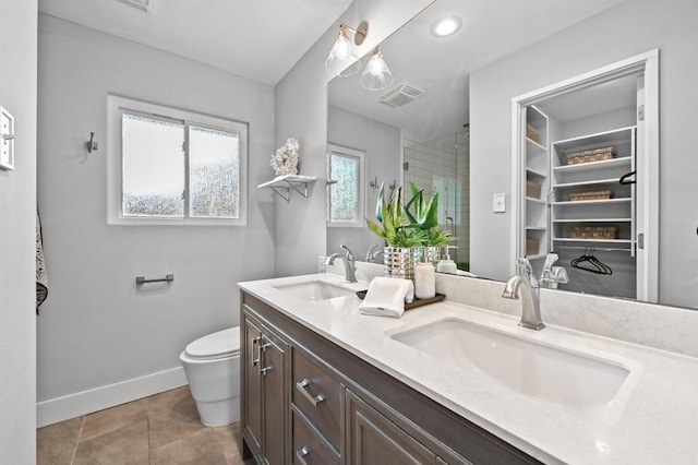 2306 Westoak Dr, Austin, TX 78704 - full bathroom featuring double vanity, a stall shower, a walk in closet, tile patterned floors, and recessed lighting