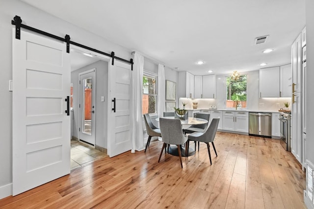 2306 Westoak Dr, Austin, TX 78704 - dining space featuring a barn door, plenty of natural light, light wood-type flooring, and recessed lighting