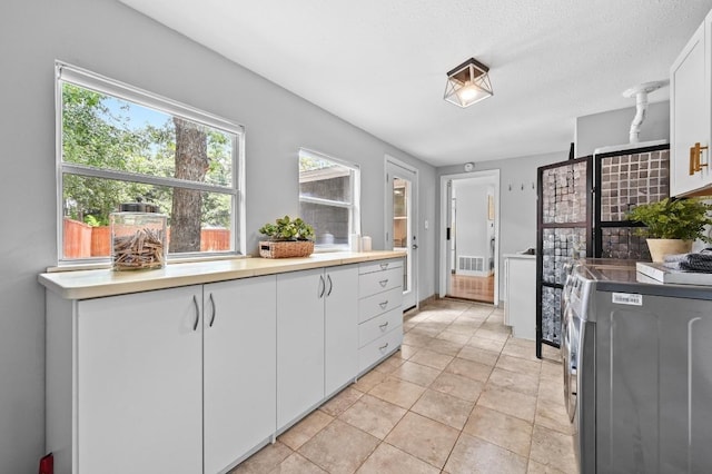 2306 Westoak Dr, Austin, TX 78704 - kitchen featuring white cabinets, light countertops, and light tile patterned floors