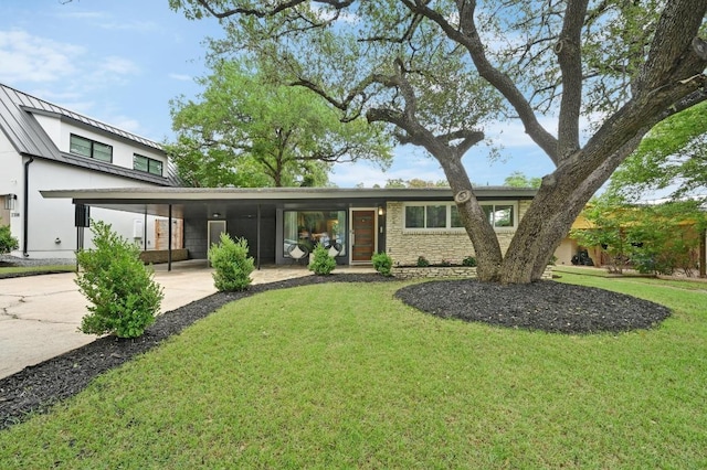 2306 Westoak Dr, Austin, TX 78704 - view of front of property with a standing seam roof, a front lawn, concrete driveway, an attached carport, and a metal roof