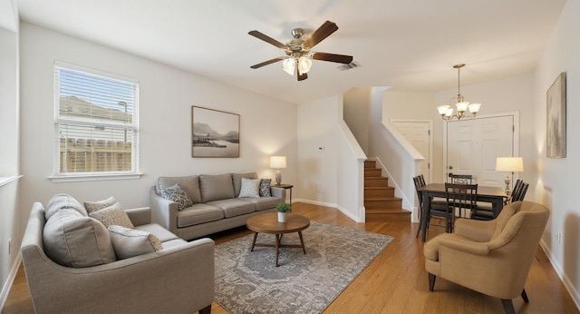 5809 Needle Nook Ct, Austin, TX 78744 - living room with stairs, wood finished floors, a chandelier, and ceiling fan