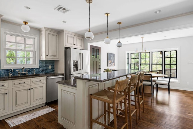 1118 Reagan Ter, Austin, TX 78704 - kitchen with appliances with stainless steel finishes, decorative backsplash, ornamental molding, plenty of natural light, and dark wood finished floors