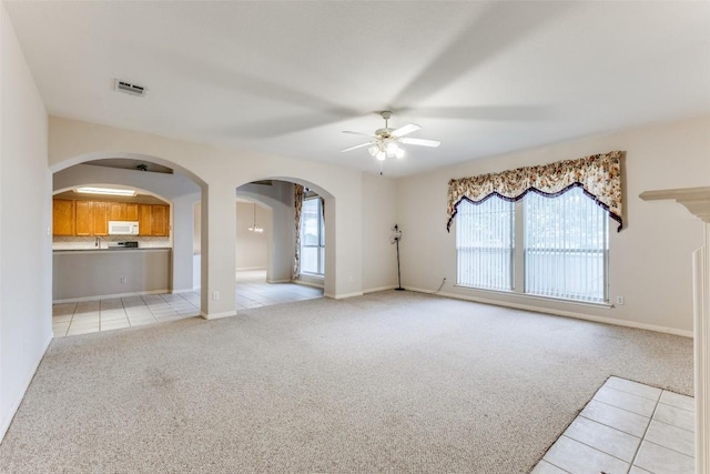 601 Indian Run Dr, Pflugerville, TX 78660 - unfurnished living room featuring a ceiling fan, light tile patterned floors, and light colored carpet