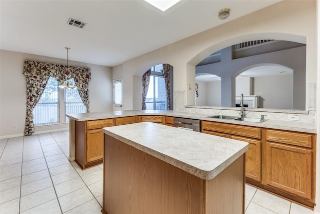 601 Indian Run Dr, Pflugerville, TX 78660 - kitchen with light tile patterned floors, light countertops, a kitchen island, hanging light fixtures, and a peninsula