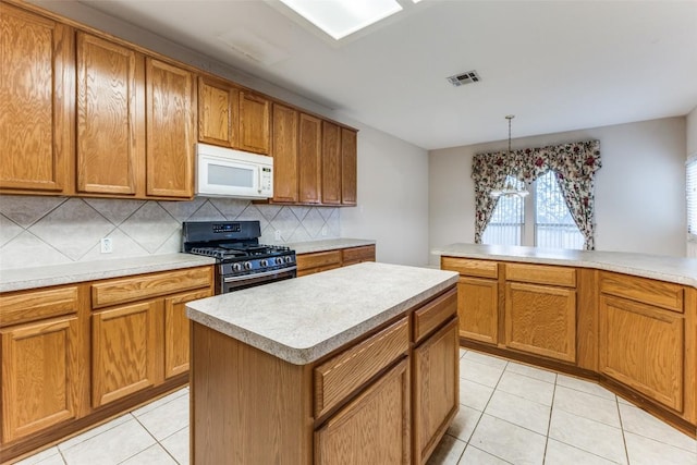 601 Indian Run Dr, Pflugerville, TX 78660 - kitchen with stainless steel gas stove, white microwave, decorative backsplash, and light countertops