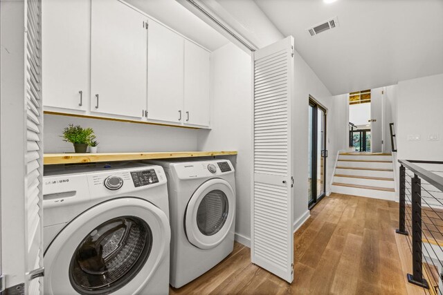 3704 Laurel Ledge Ln, Austin, TX 78731 - laundry area featuring separate washer and dryer, cabinet space, and light wood finished floors