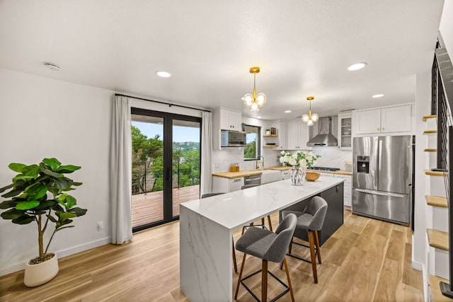 3704 Laurel Ledge Ln, Austin, TX 78731 - kitchen with appliances with stainless steel finishes, wall chimney exhaust hood, open shelves, recessed lighting, and a kitchen breakfast bar