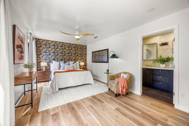 3704 Laurel Ledge Ln, Austin, TX 78731 - bedroom with light wood-type flooring, wallpapered walls, an accent wall, ensuite bath, and a ceiling fan